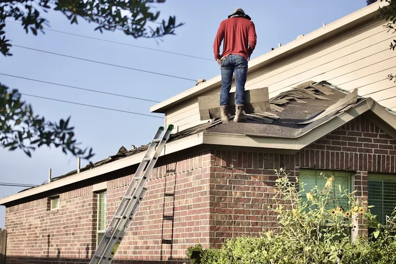 Professional roofer working on a residential roof in Riverby Estates